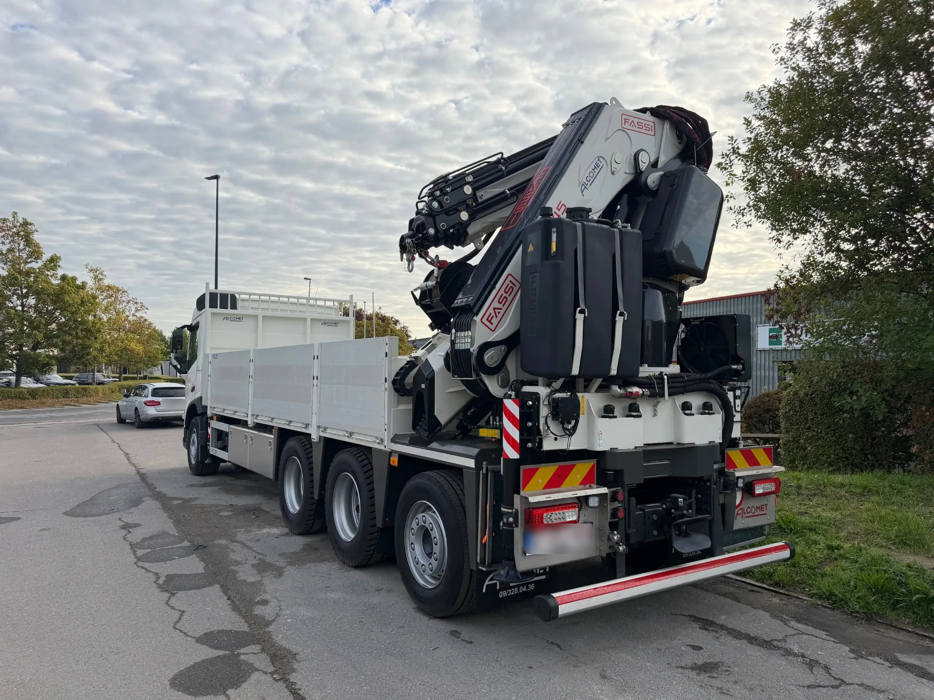 Kraanwagen van Fram met opgeplooide kraanarm achteraan de laadbak
